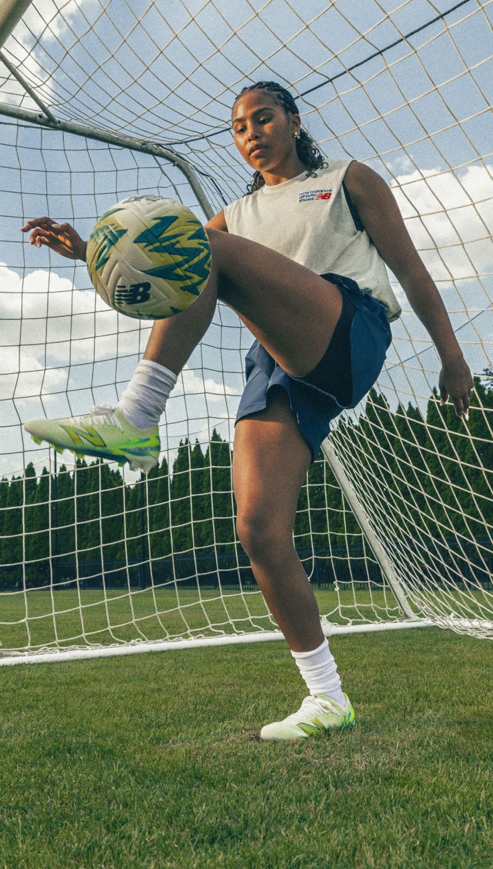 A woman kicking a soccer ball.
