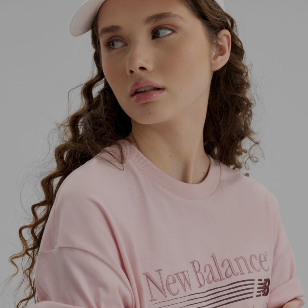 Close-up of a woman wearing a light pink shirt and hat.