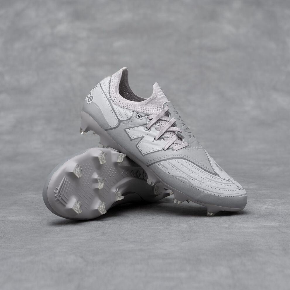 A pair of New Balance Furon v7 football cleats on a grey studio backdrop.