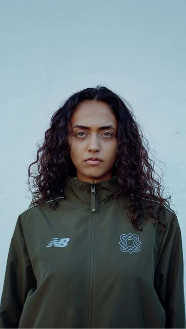 Headshot of a woman standing against a blue wall