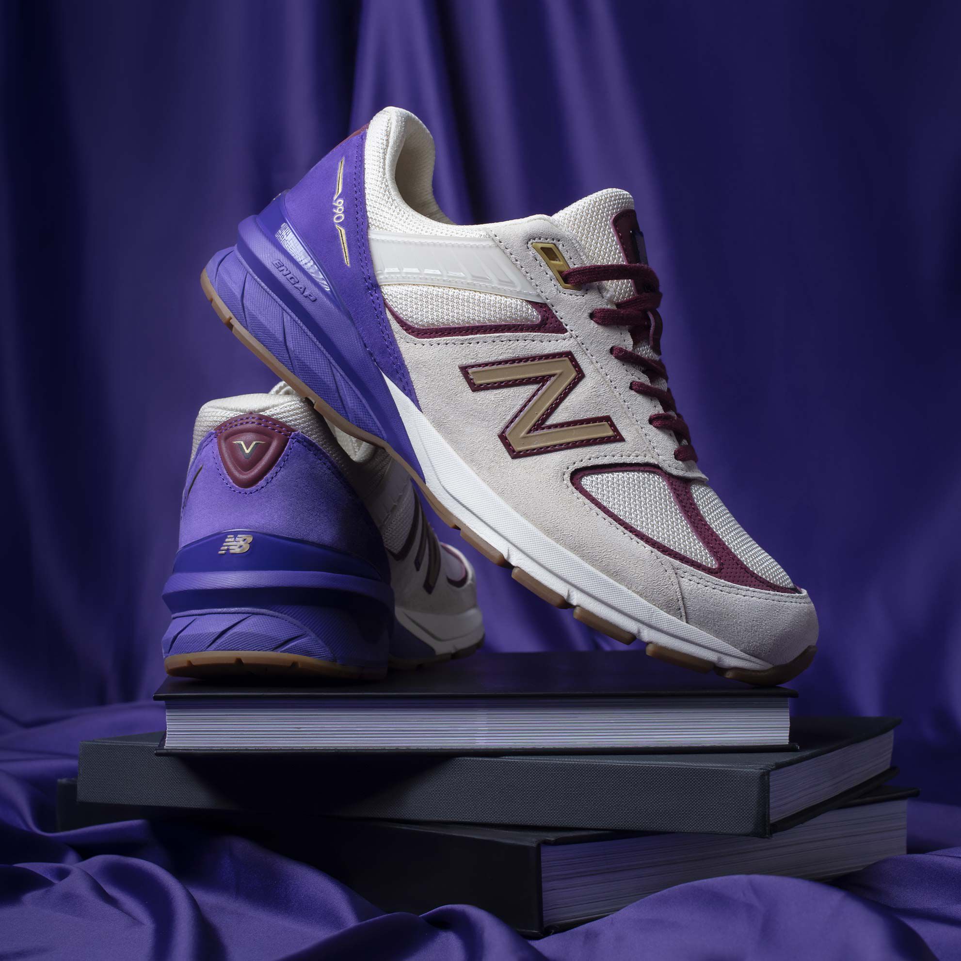 Black History Month exclusive 990 pair sitting on black books with velvet background.