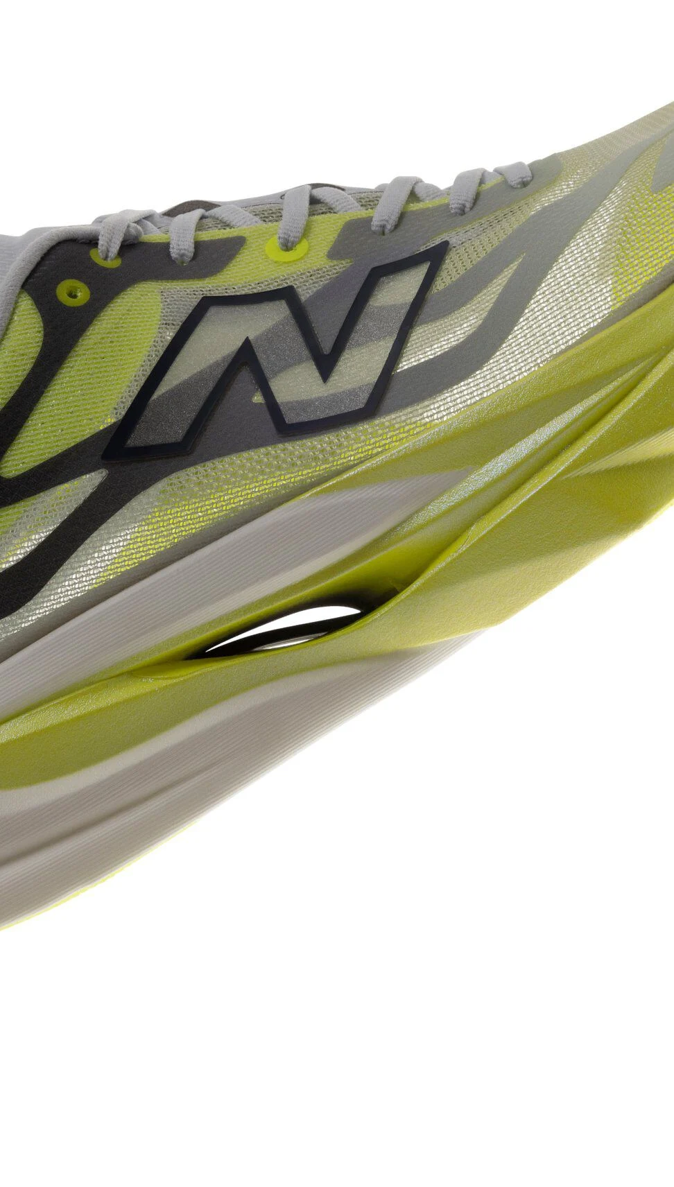 Close-up of a New Balance running shoe with a translucent gray-and-lime mesh upper, oversized black-outlined &ldquo;N&rdquo; logo, and sculpted lime-green cushioned midsole.&nbsp;