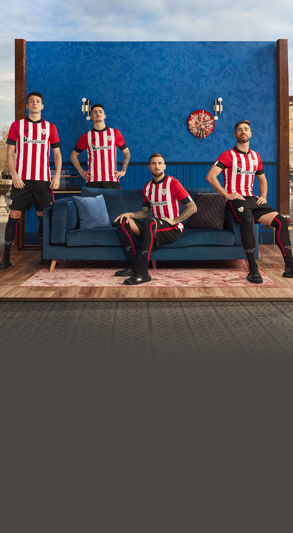 Four members of the Athletic Club team sitting around a blue couch.    
