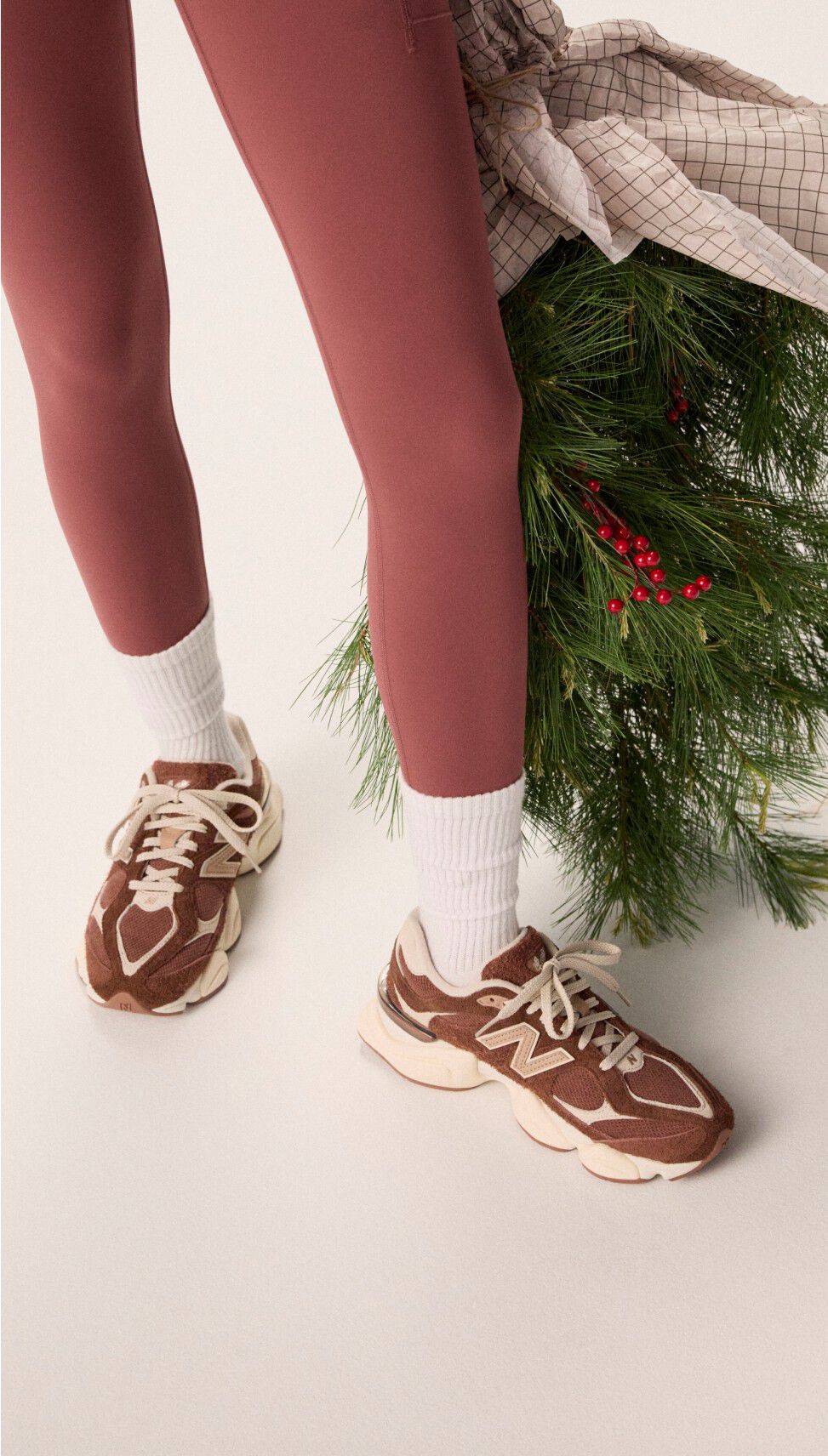 Woman wearing maroon tights holding a bag of garland.