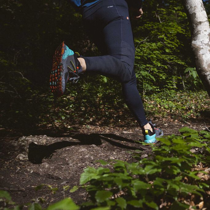 Man running in Fresh Foam Hierro trail shoes and black tights on a wooded trail