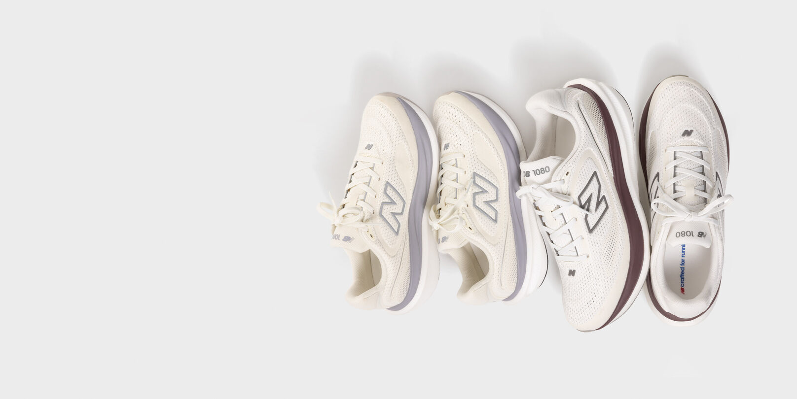 Two pairs of 1080 shoes on a grey background.