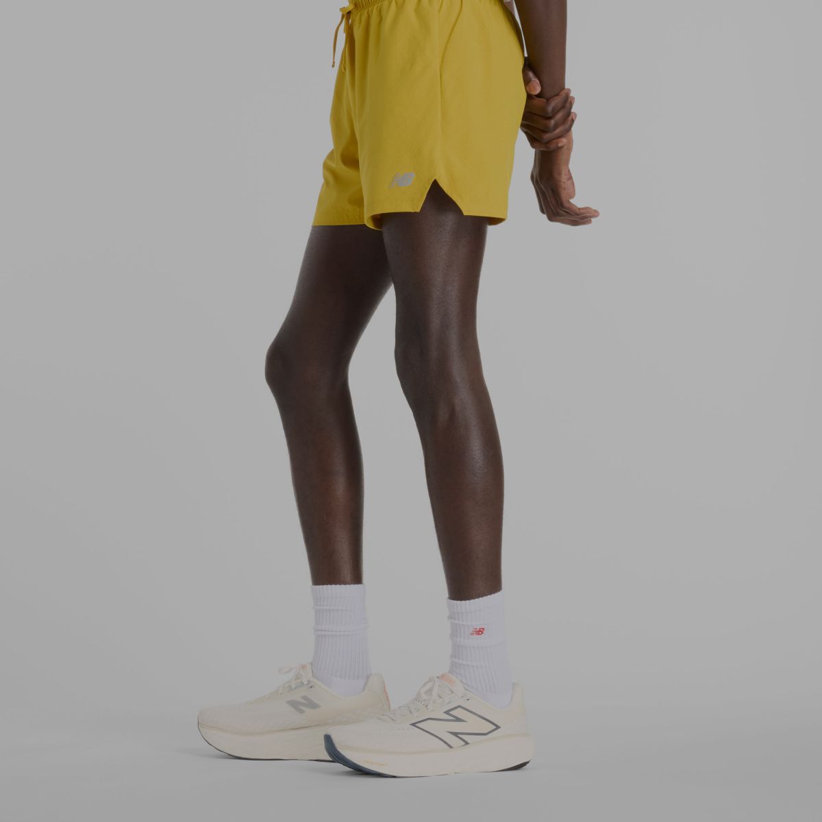 A man wearing yellow New Balance shorts.