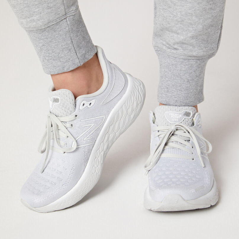 Running shoes on a model in grey sweatpants.