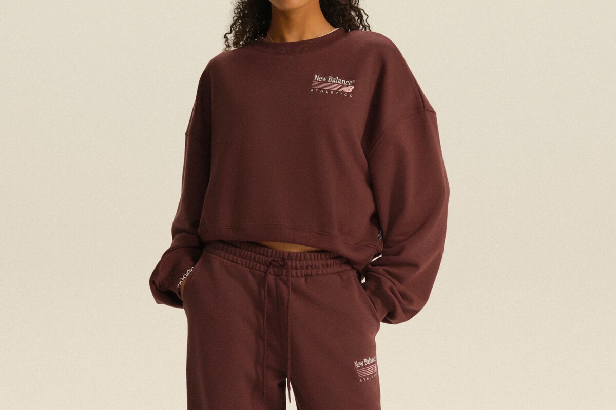 Person wearing a burgundy New Balance Athletics sweatshirt and matching joggers in a clean studio setting.