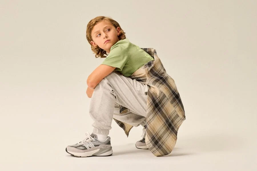 Boy wearing a pair of 990v6 shoes.