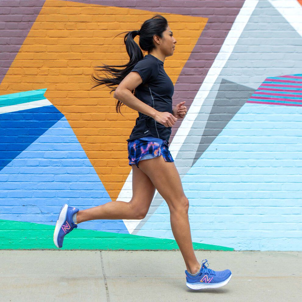 Side profile of Track & Field athlete, Brenda Martinez, running in front of a colorful geometric wall mural