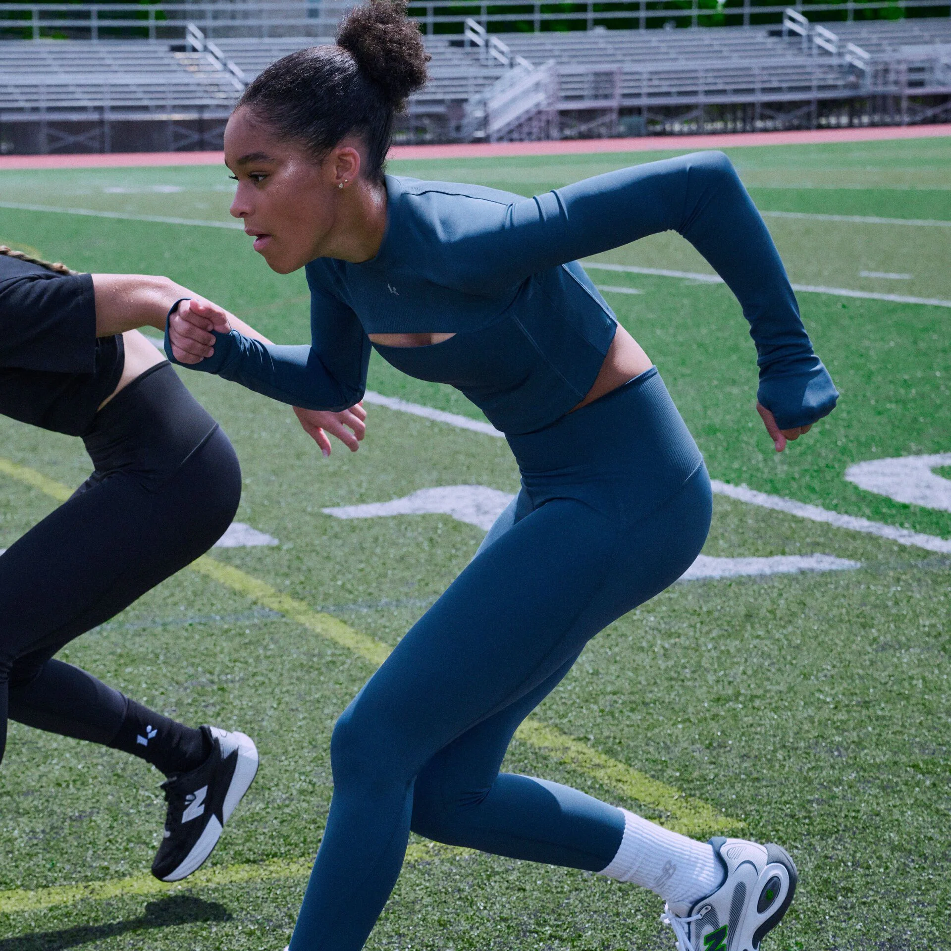 Athlete in a blue performance set sprinting across a football field during agility training.