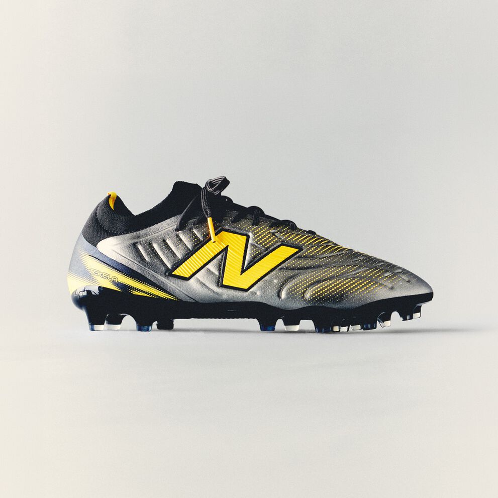 Black and yellow New Balance soccer cleat with textured detailing and molded studs displayed against a clean white background.