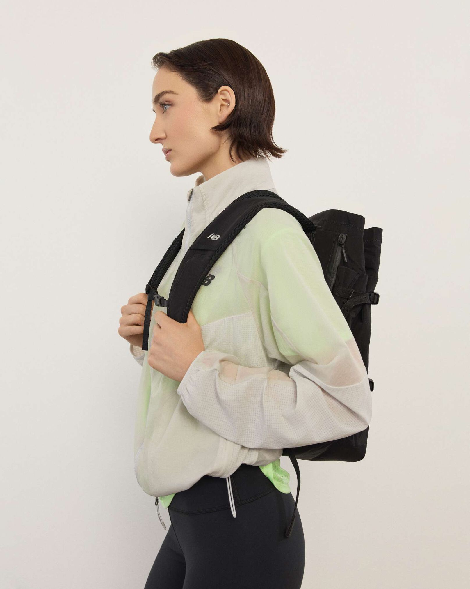 A woman standing in front a white wall.