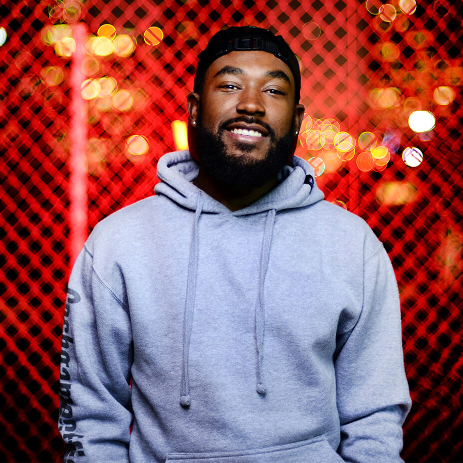Skateboarder Marquise Henry smiling in a grey hoodie and black snapback
