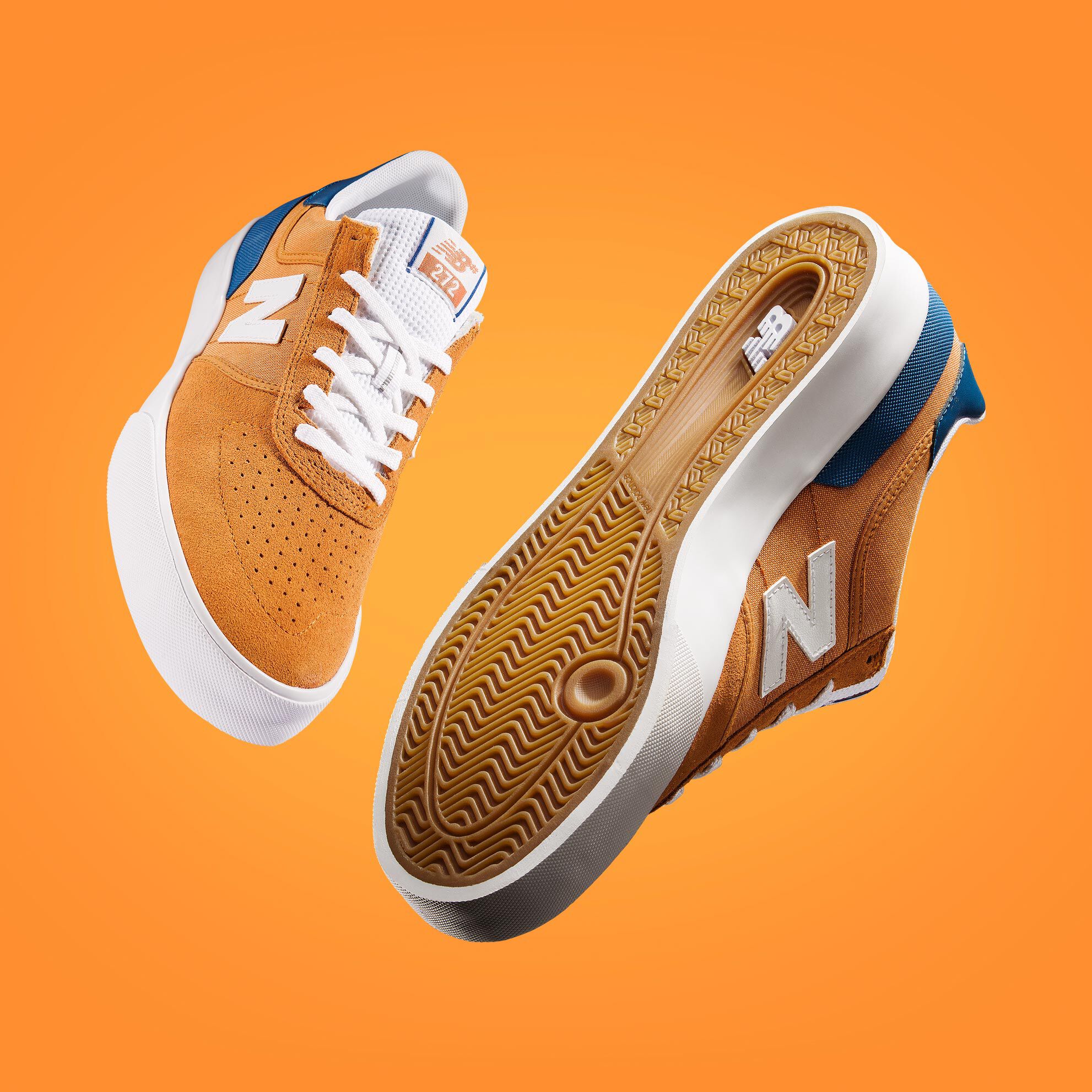 A pair of orange and blue NB Numeric 272 skate shoes floating on an orange background