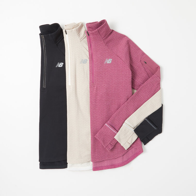 Three women’s long sleeve jackets laying on top of each other on a grey background.