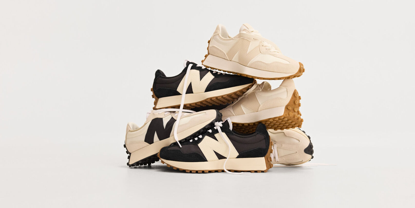 Pile of multiple New Balance sneakers on white background. 
