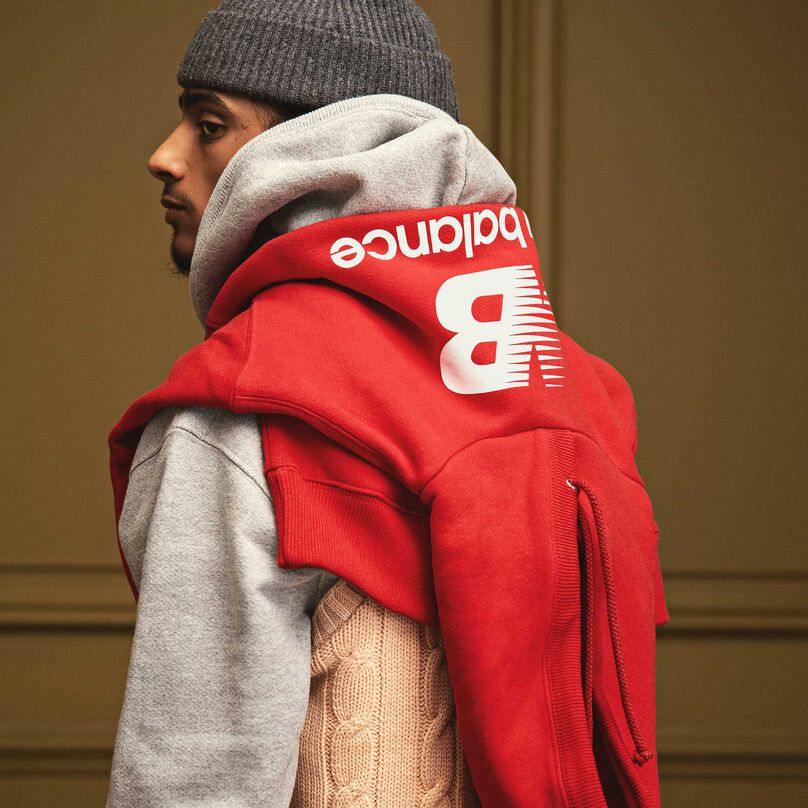 A man looking over his shoulder with the MADE in USA Heritage Hoodie drapped over his shoulders.
