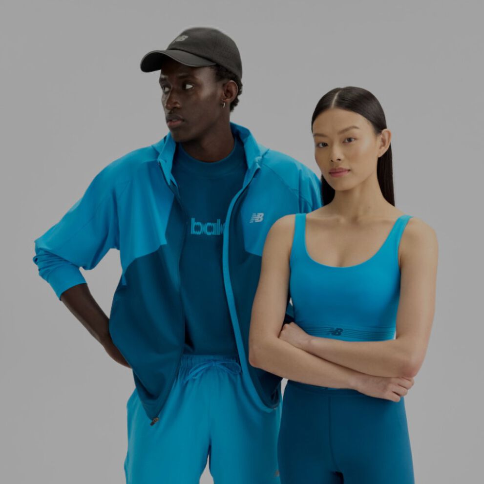  A man and woman wearing blue New Balance gear on a white background.