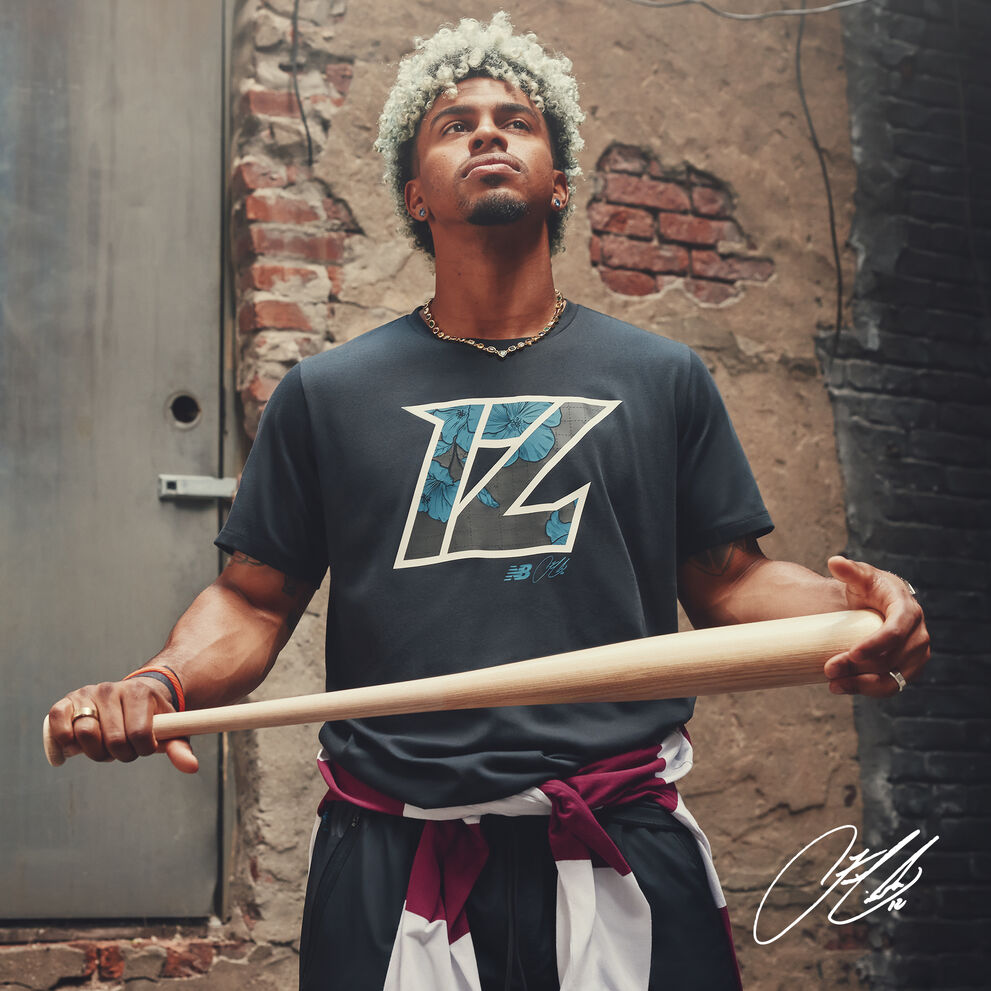 Francisco holding a bat in an alley looking up at the sky. 