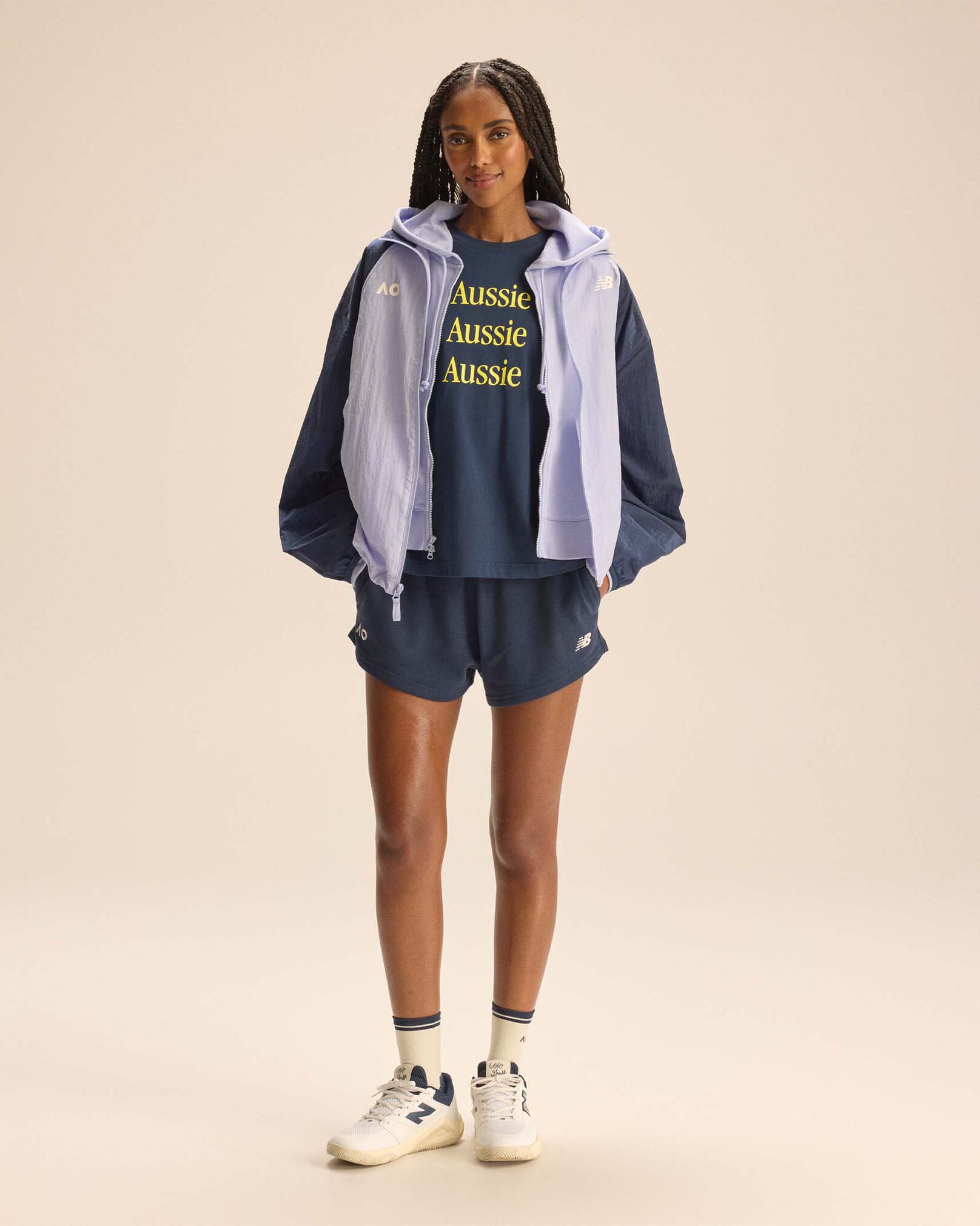 A person standing against a tan studio backdrop.