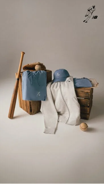 Blue and grey clothes placed on wooden boxes with a baseball bat leaning against it.