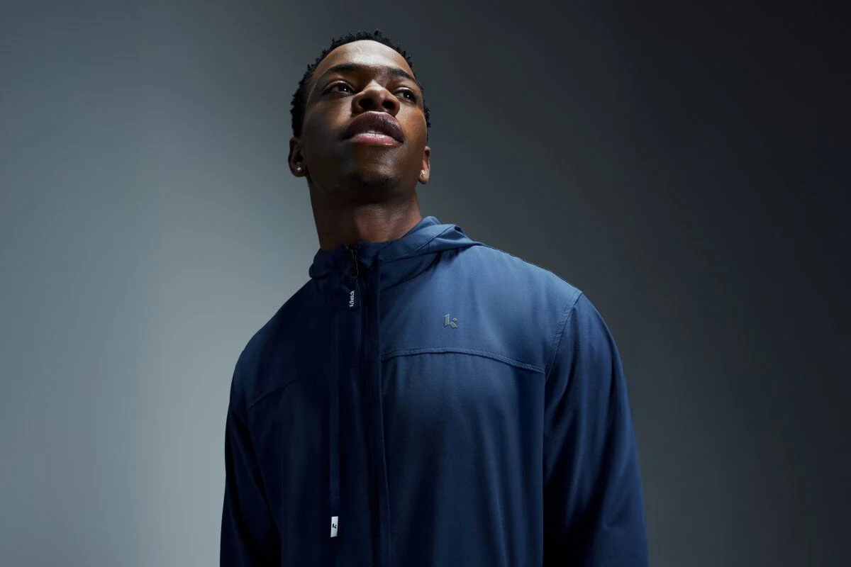 Man wearing a navy athletic jacket, shown from the chest up.