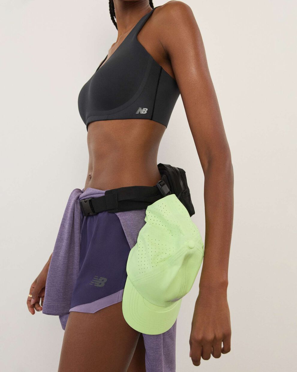 A woman standing in front a white wall.