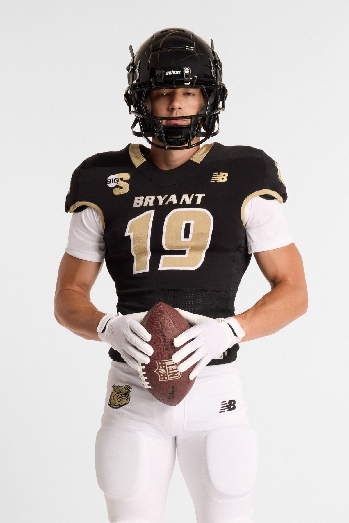 Athlete wearing a black and gold Bryant football uniform with number 19, helmet, white pants, and holding a football.