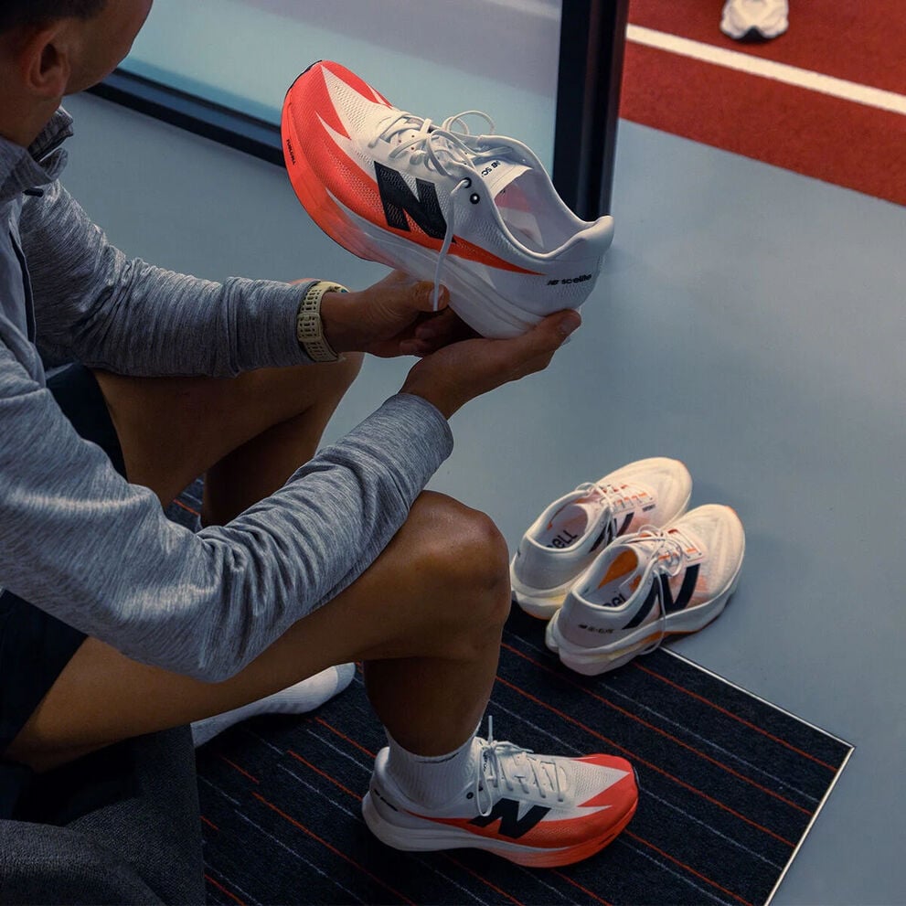 A person sitting and looking at a shoe in their hand.