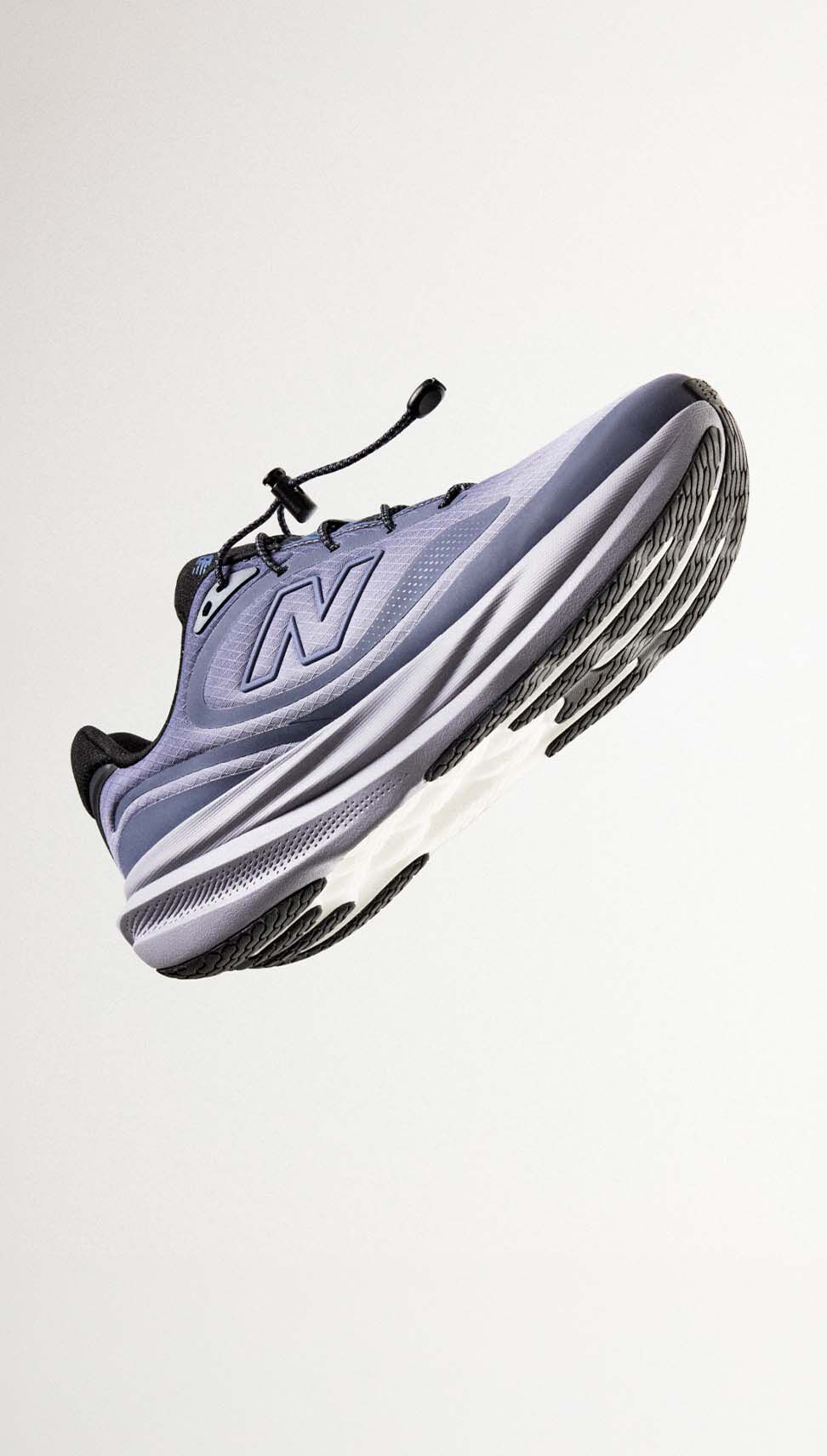 A blue 1080 shoe against a grey studio background.