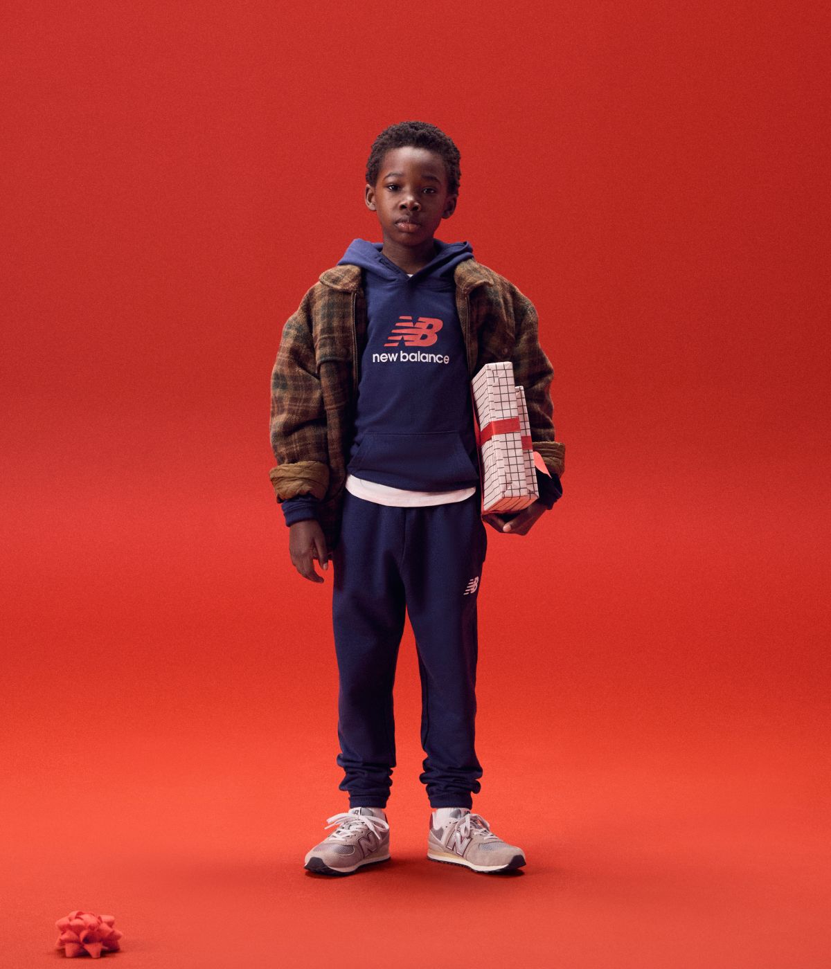 Kid holding gifts on a red background.