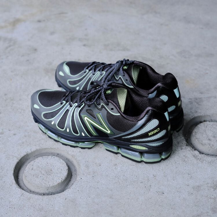 Off figure shot of a pair of lime green and black shoes on concrete with circles.