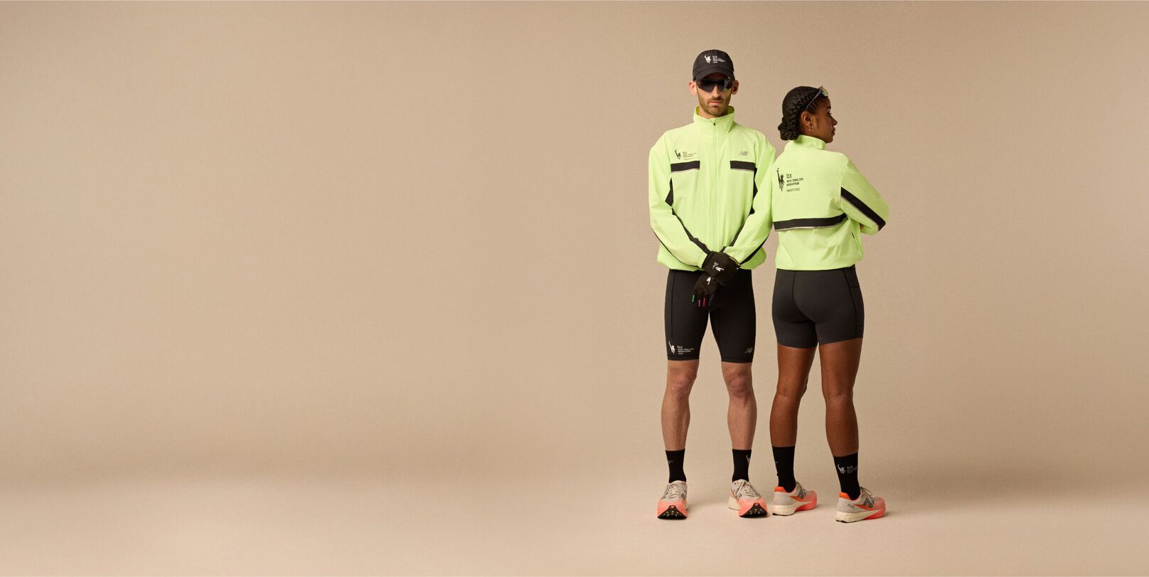 A man and woman wearing neon yellow jacket and running apparel in front of a beige background. 