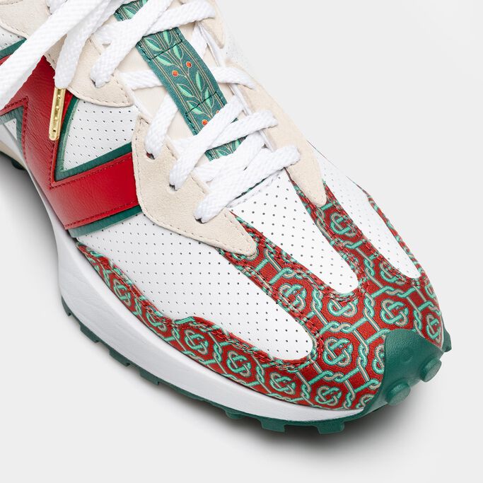 A close-up crop of the toe and tongue of a white, red, and green NB x Casablanca 327 sneaker