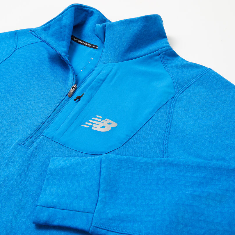 Blue men’s jacket laying on a grey background focusing on the collar.