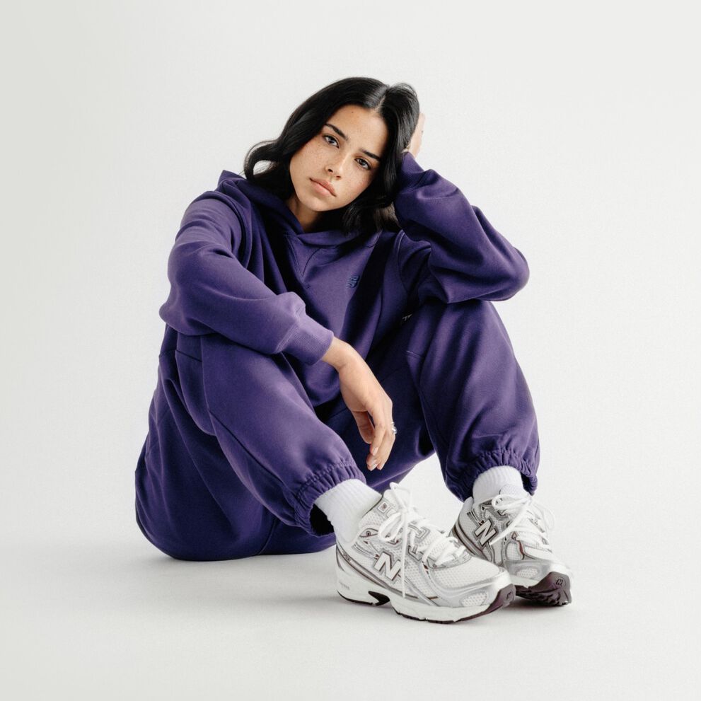A woman sitting on a grey studio backdrop