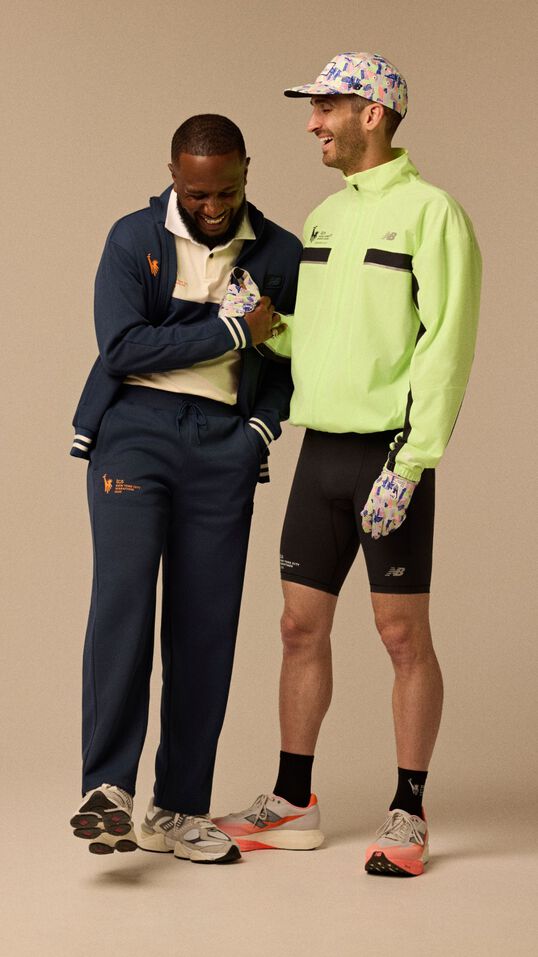 Two men wearing running apparel in a full body image with a beige background. 