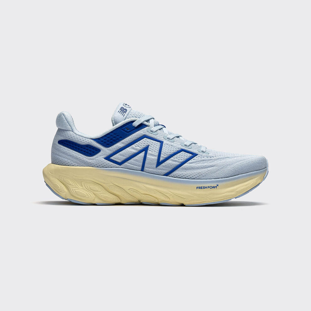 One blue Fresh Foam X 1080v13 shoe in studio on a grey background.  