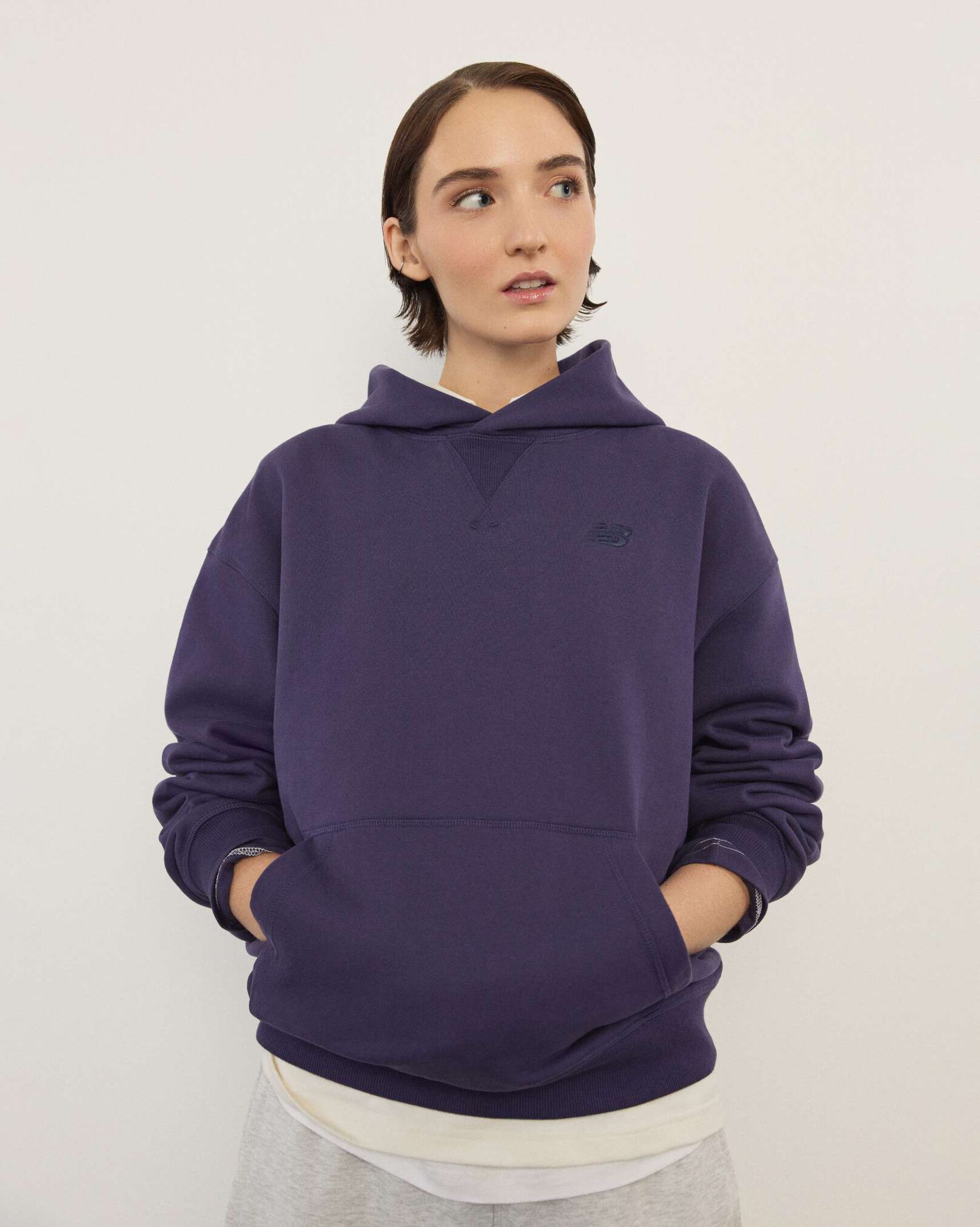 A woman standing in front a white wall.