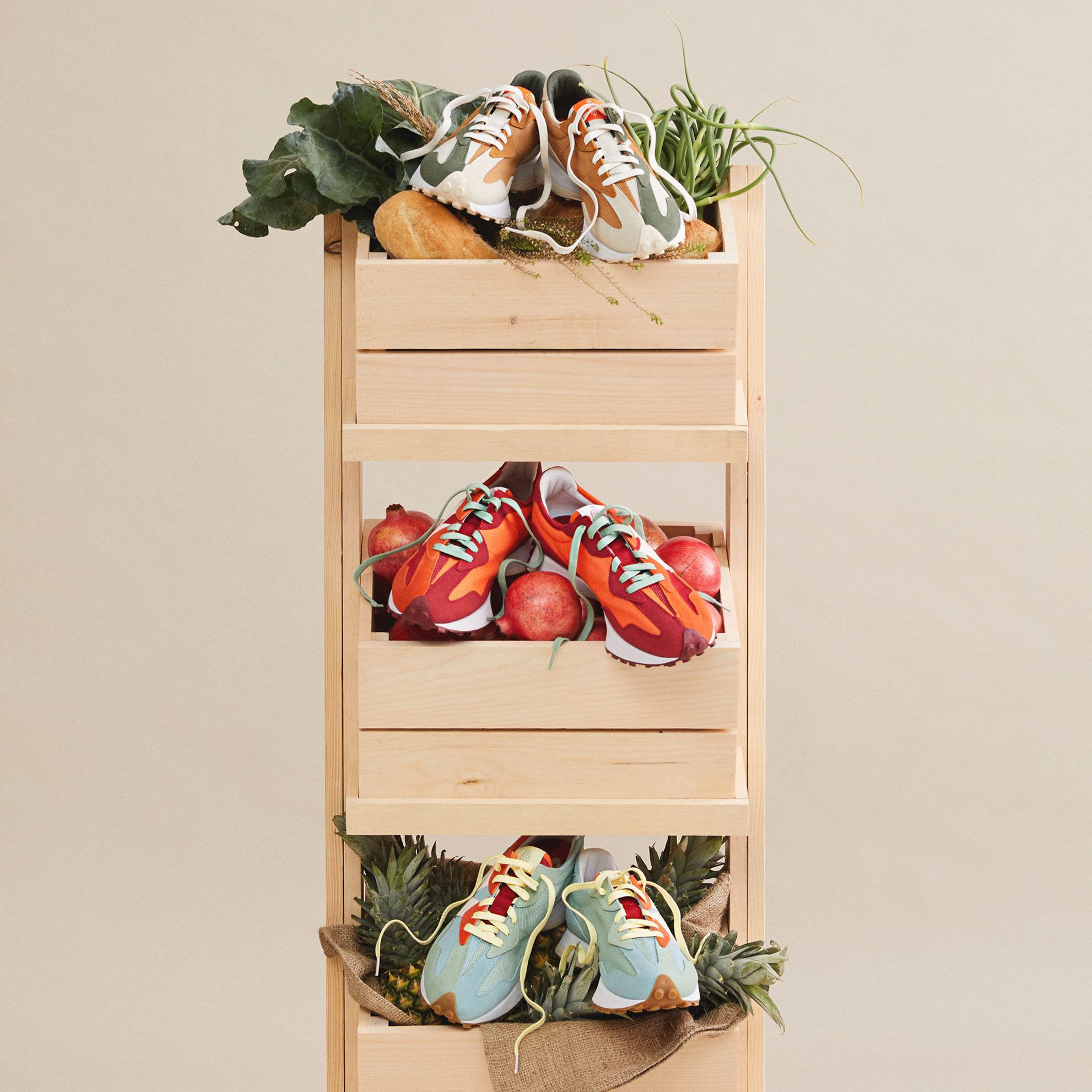 Collection of 327 shoes sitting on top of a produce stand with 3 wooden boxes containing pomegranate, pineapple and bread