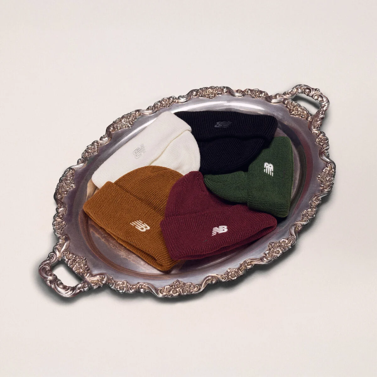 Silver platter holding five different color beanies.