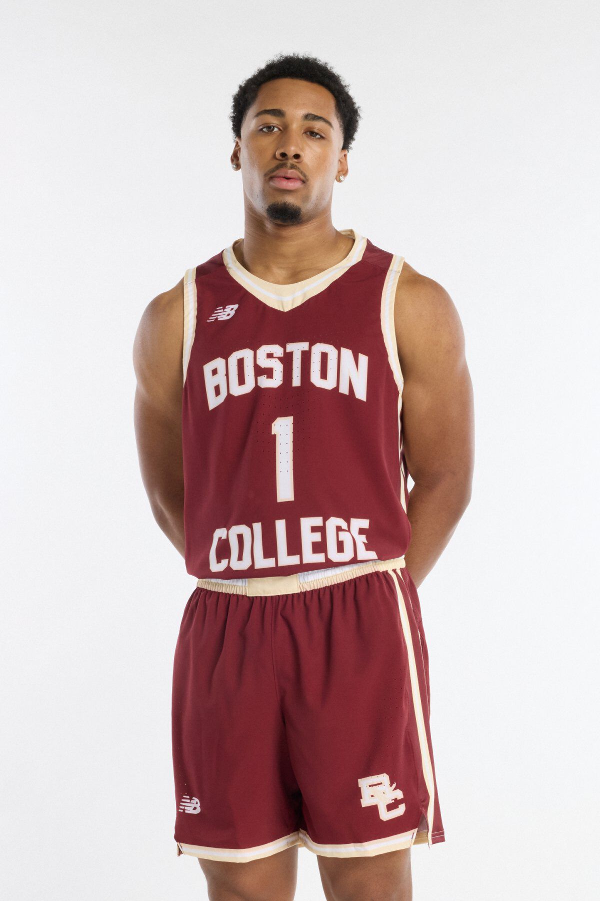 Young man wearing a maroon Boston College basketball jersey with number 1 and matching shorts, standing against a light background.
