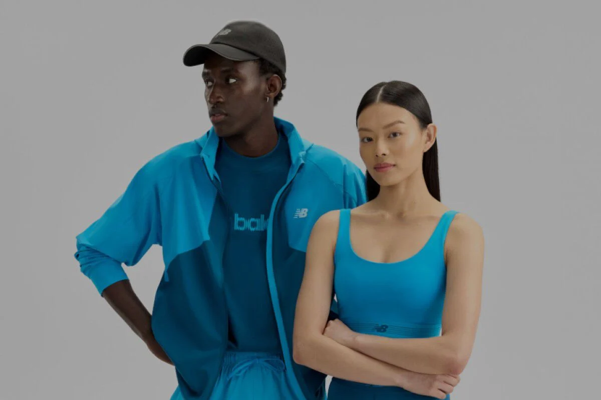  A man and woman wearing blue New Balance gear on a white background.