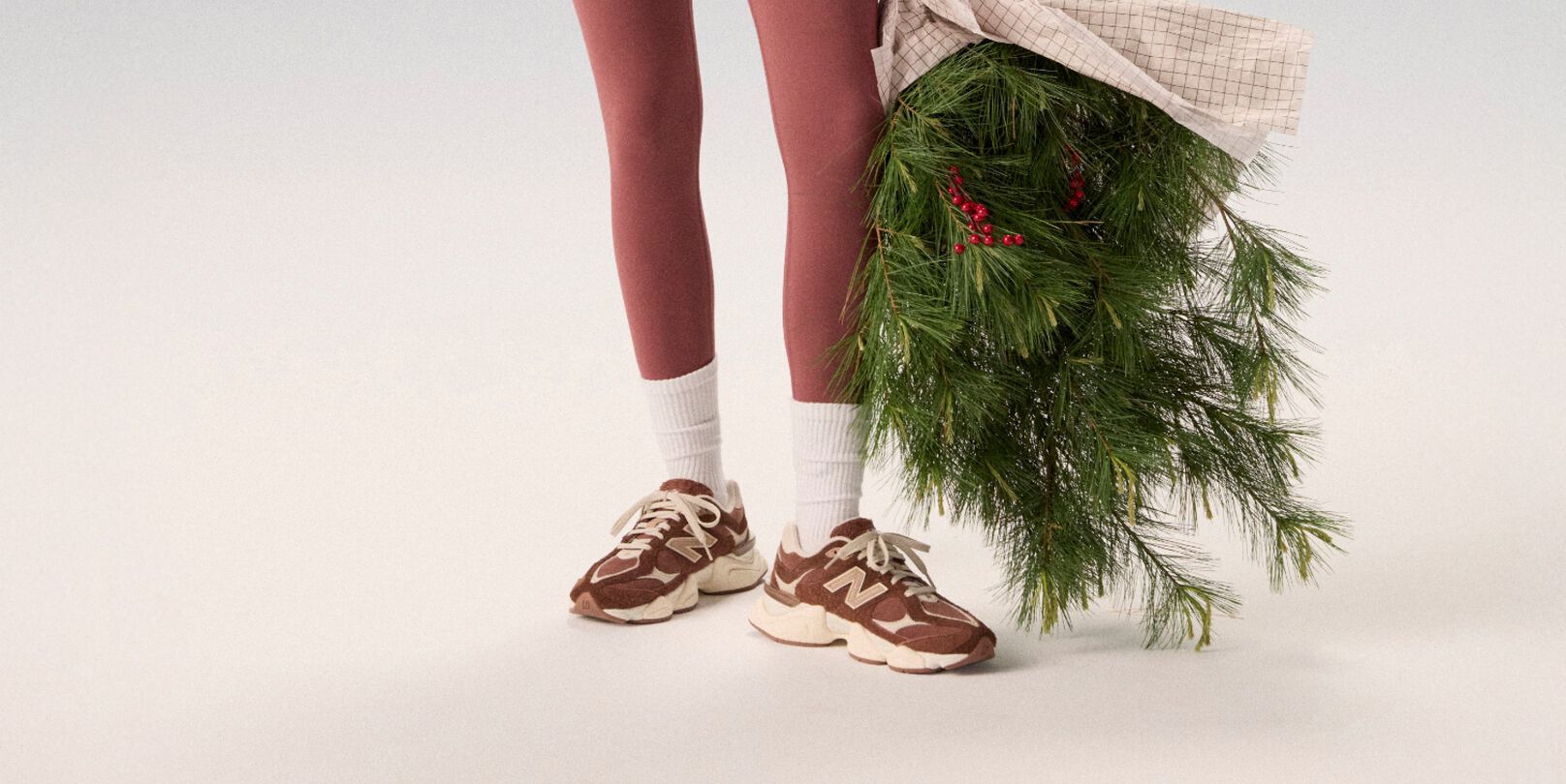 Young woman in maroon tights holding a bag of garland.