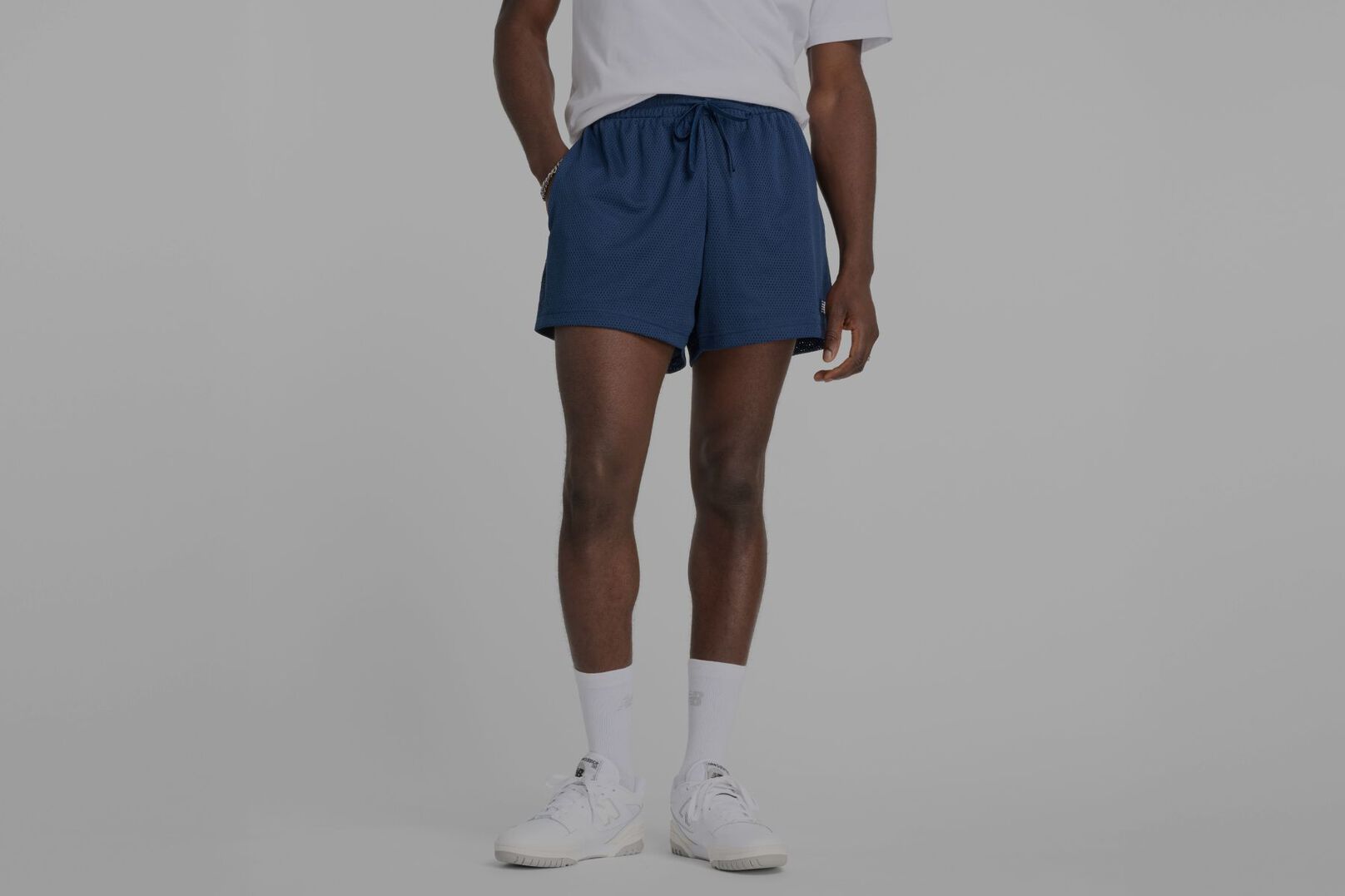 Persona con pantalones cortos marrones de New Balance.