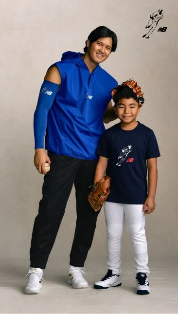 Ohtani is standing next to a kid with his glove on the boy&rsquo;s head.