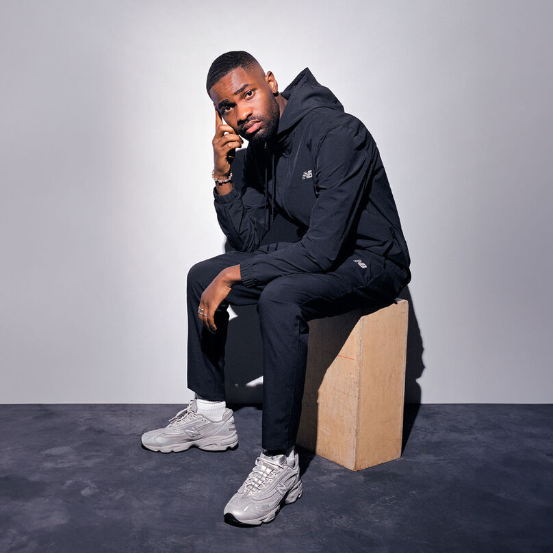 Model, sitting down, wearing the M1000TE shoes. 