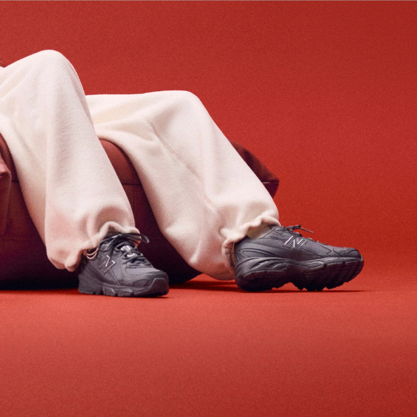 Model sitting on a couch wearing black shoes.